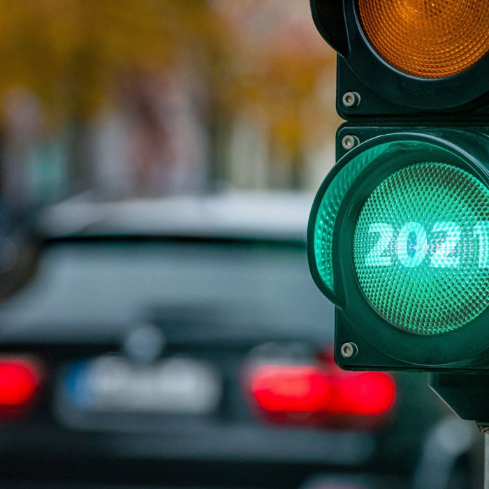 foto aproximada do sinal de trânsito (verde, amarelo e vermelho) com 2021 escrito dentro da luz verde