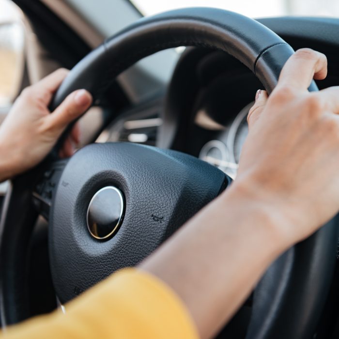 duas mãos femininas segurando o volante