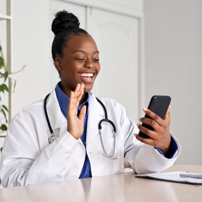 médica negra acenando para o celular ao falar com seu paciente